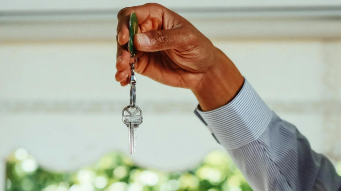 A man holding the key to his first home in Houston secured with a first-time buyer home loan from Essential Credit Union